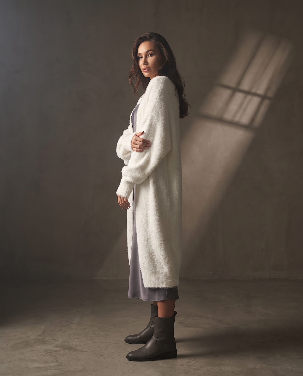 Neve Cardigan in profile against a warm greige wall