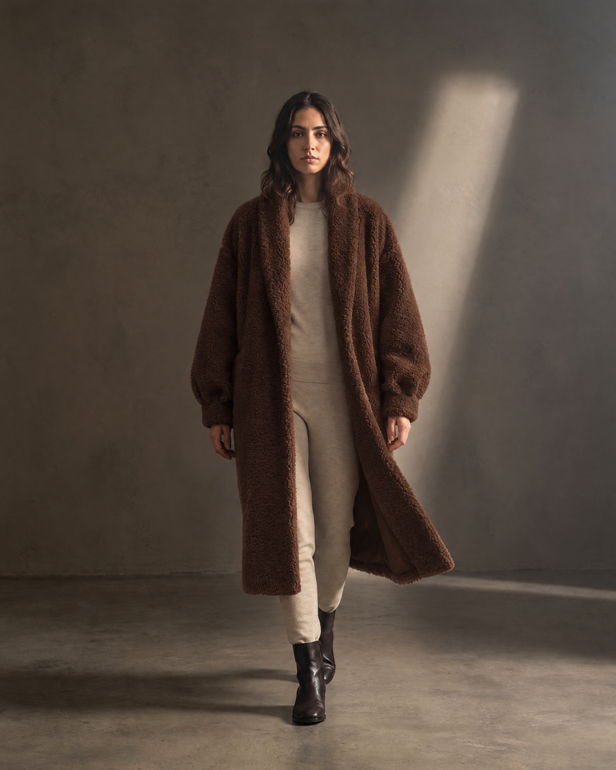 Auria Teddy Coat in chocolate, in movement against a warm greige wall